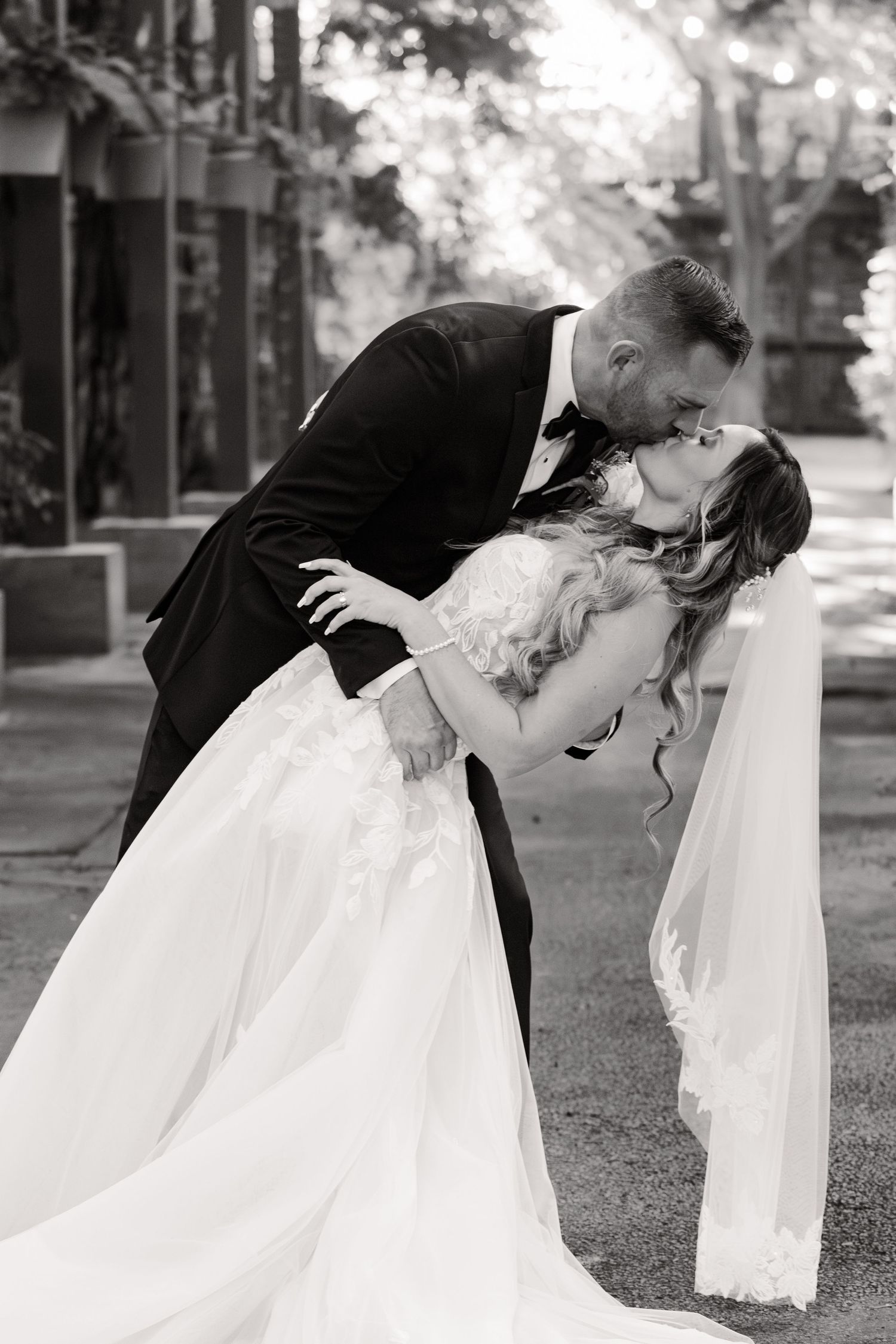 Black and white series of romantic dip kiss poses between newlyweds on their wedding day.