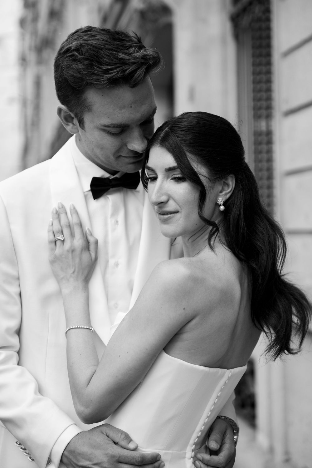 A romantic black and white wedding photo series showing intimate moments between a bride and groom.