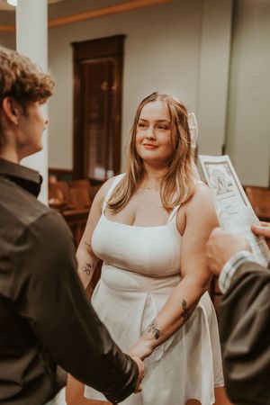 A couple shares a moment in a historic building interior with classic wooden details.