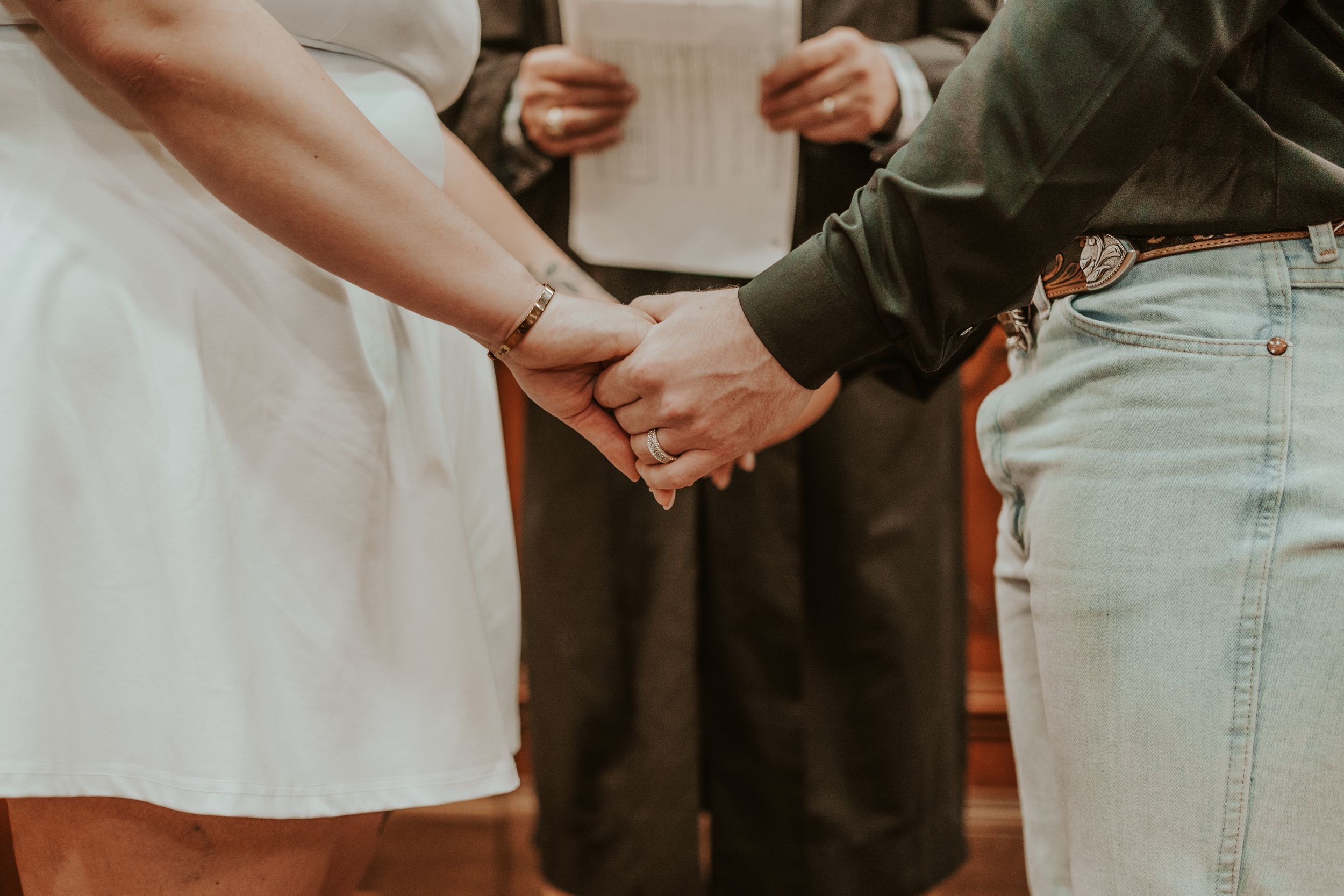 Close-up of hands joining together during an intimate ceremony moment.