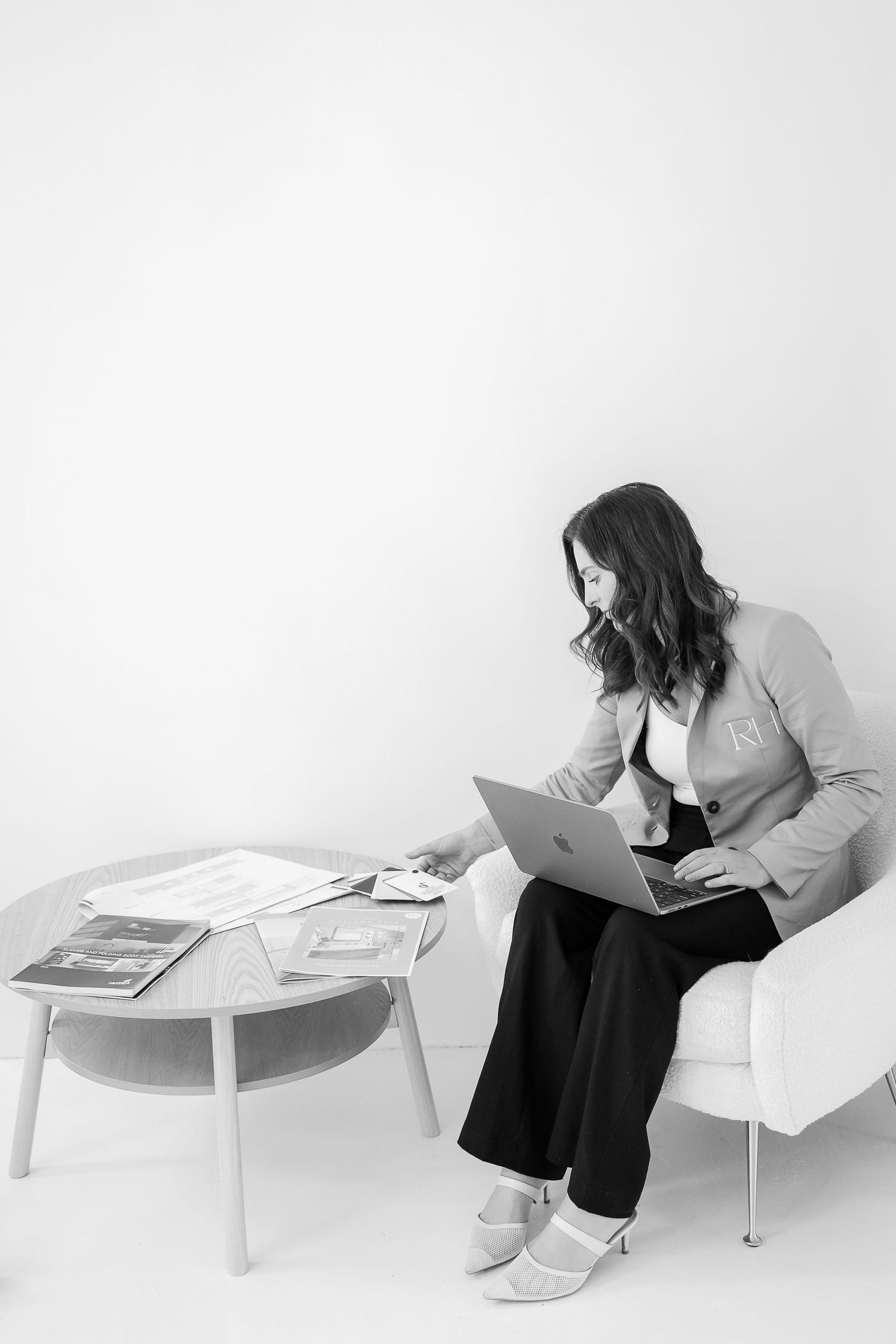 Professional reviewing documents while seated at a minimalist white desk setup.