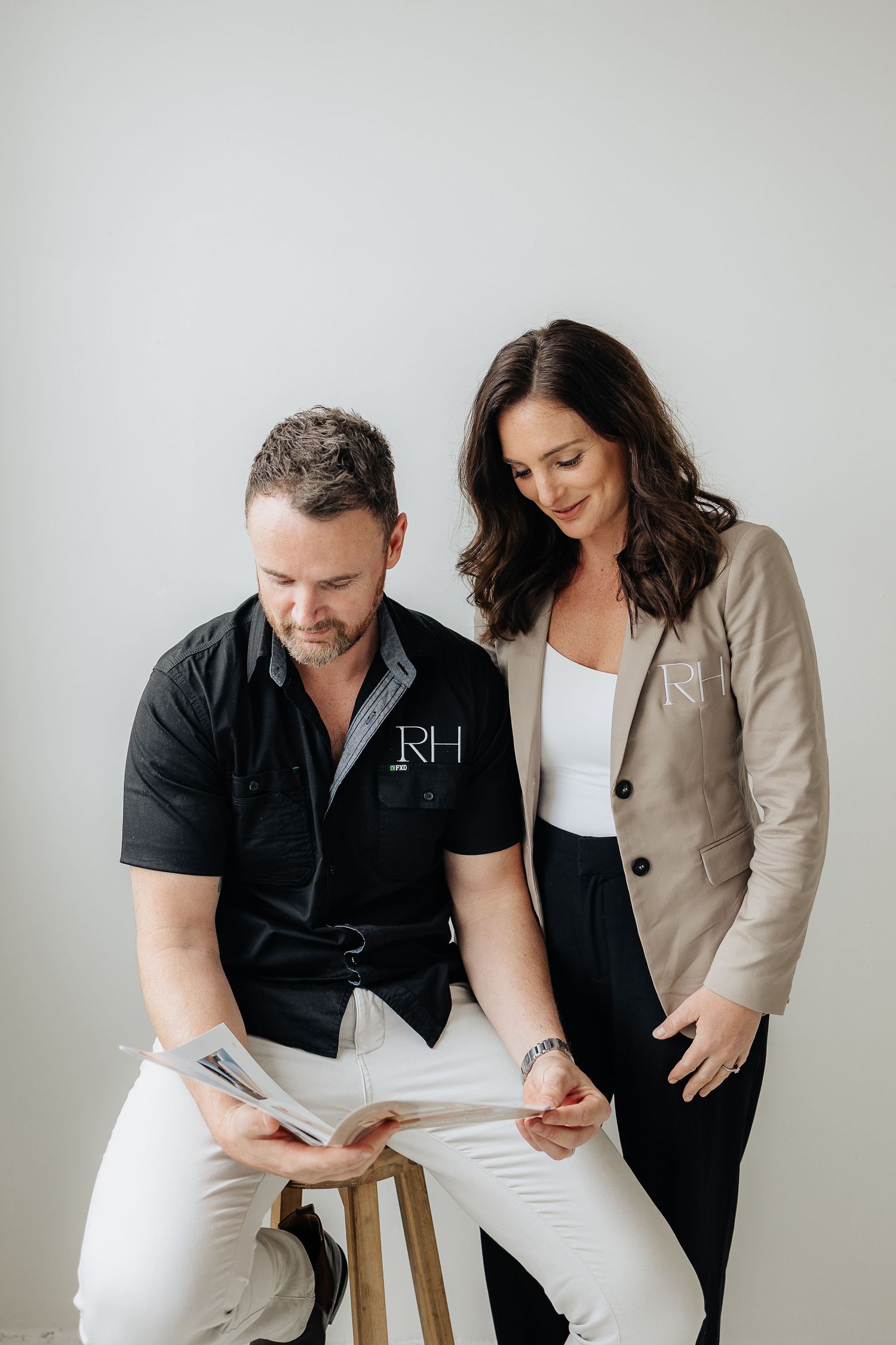 Business partners reviewing documents together in bright minimal studio setting.