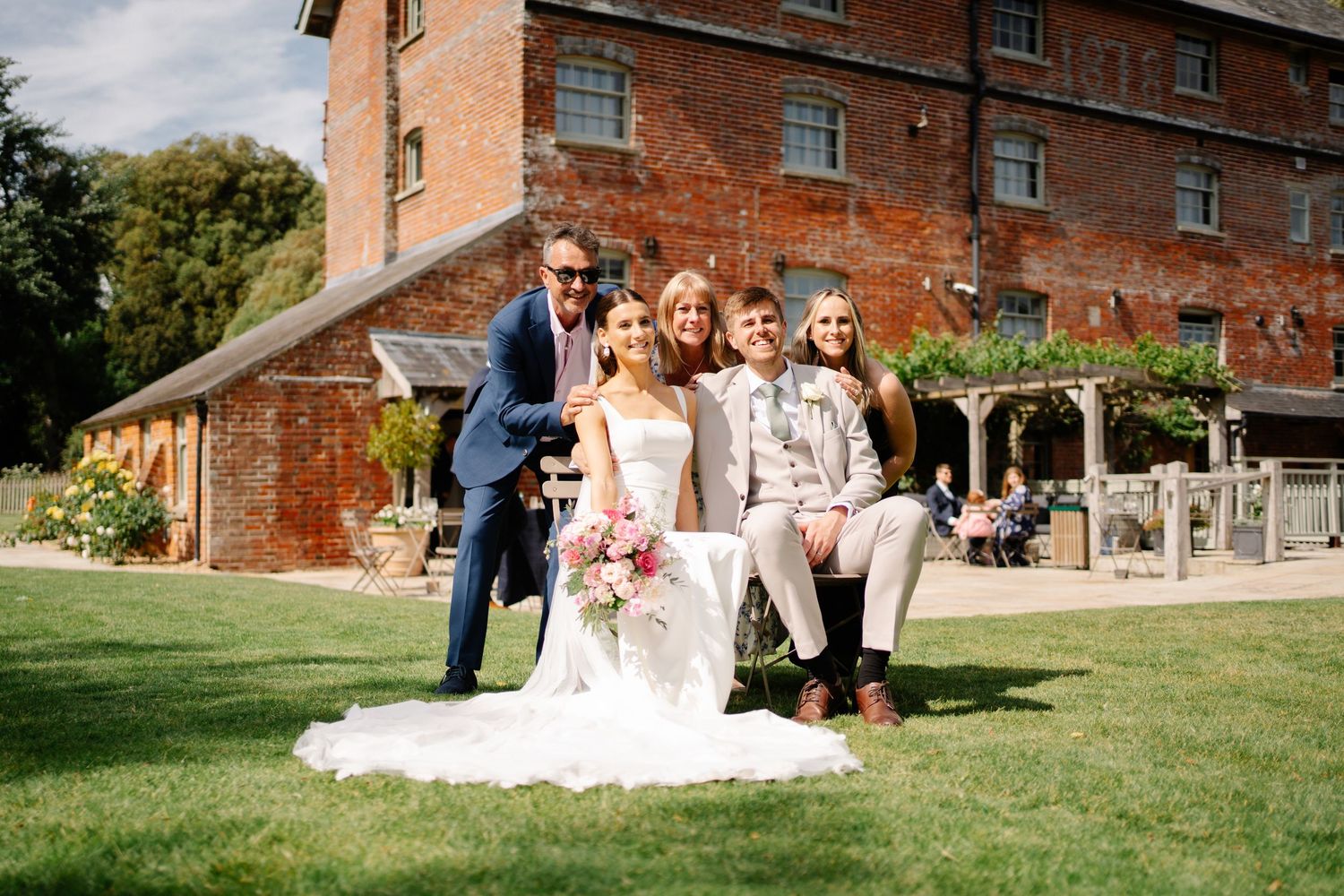 Couple sat posing for photographs with guests enjoying photo roulette together at Sopley Mill