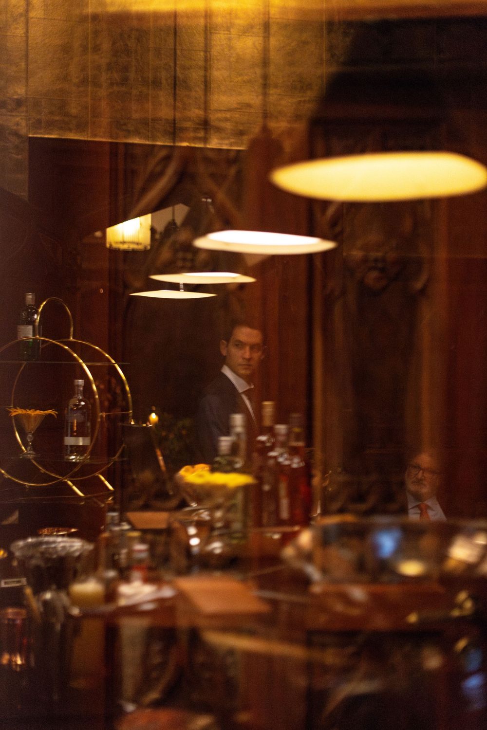 A dimly lit bar or restaurant interior with hanging pendant lights creating a warm, cozy ambiance.