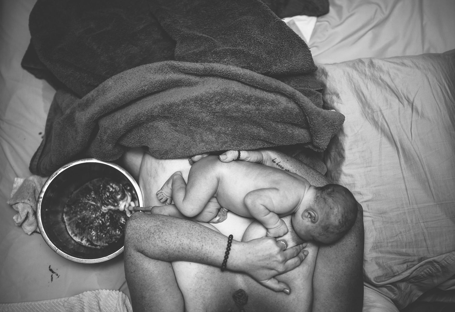 A series of black and white photos showing a sleeping baby in different positions on a bed.