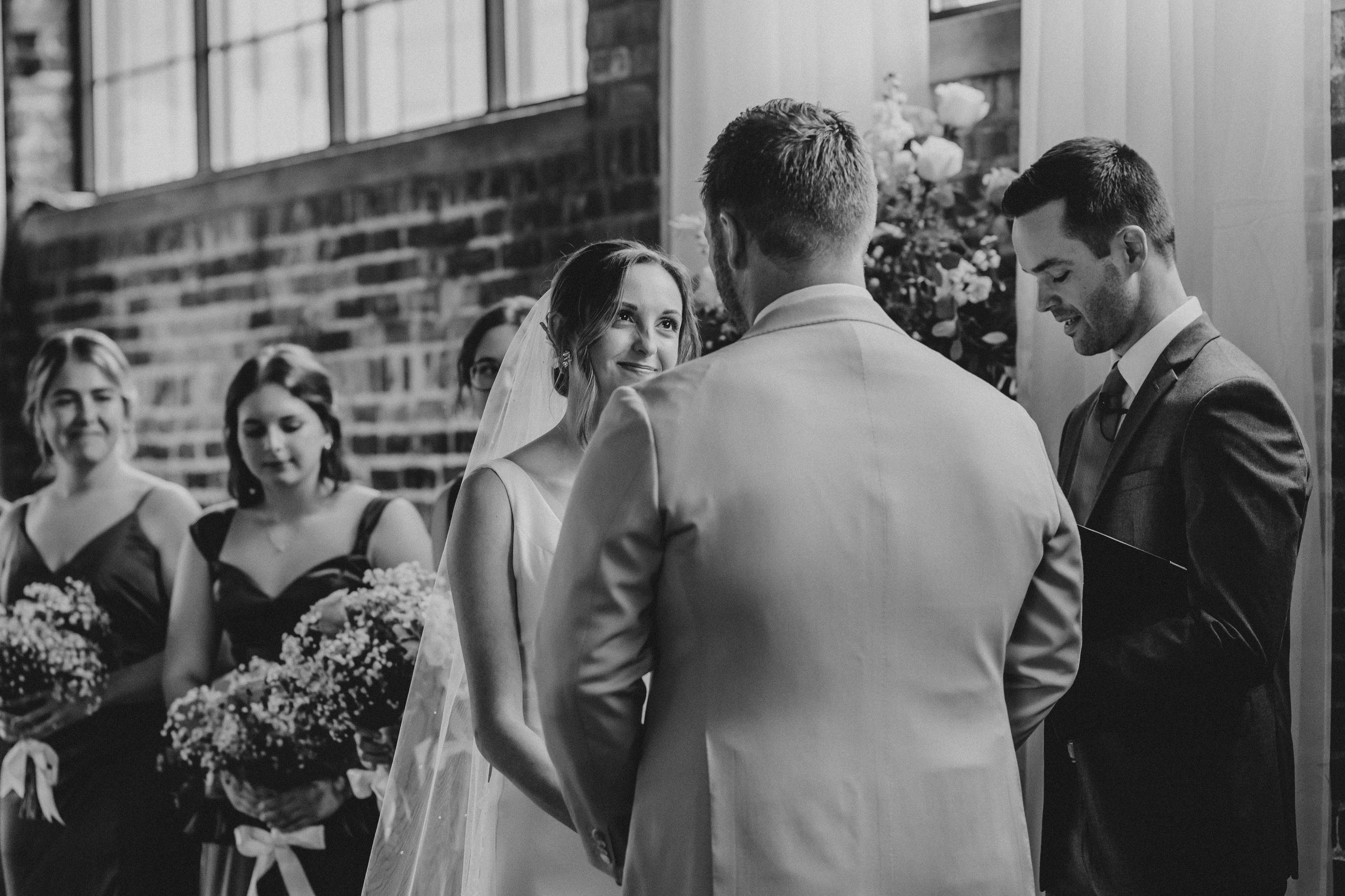 Wedding guests gather and mingle during a reception at a rustic brick venue.