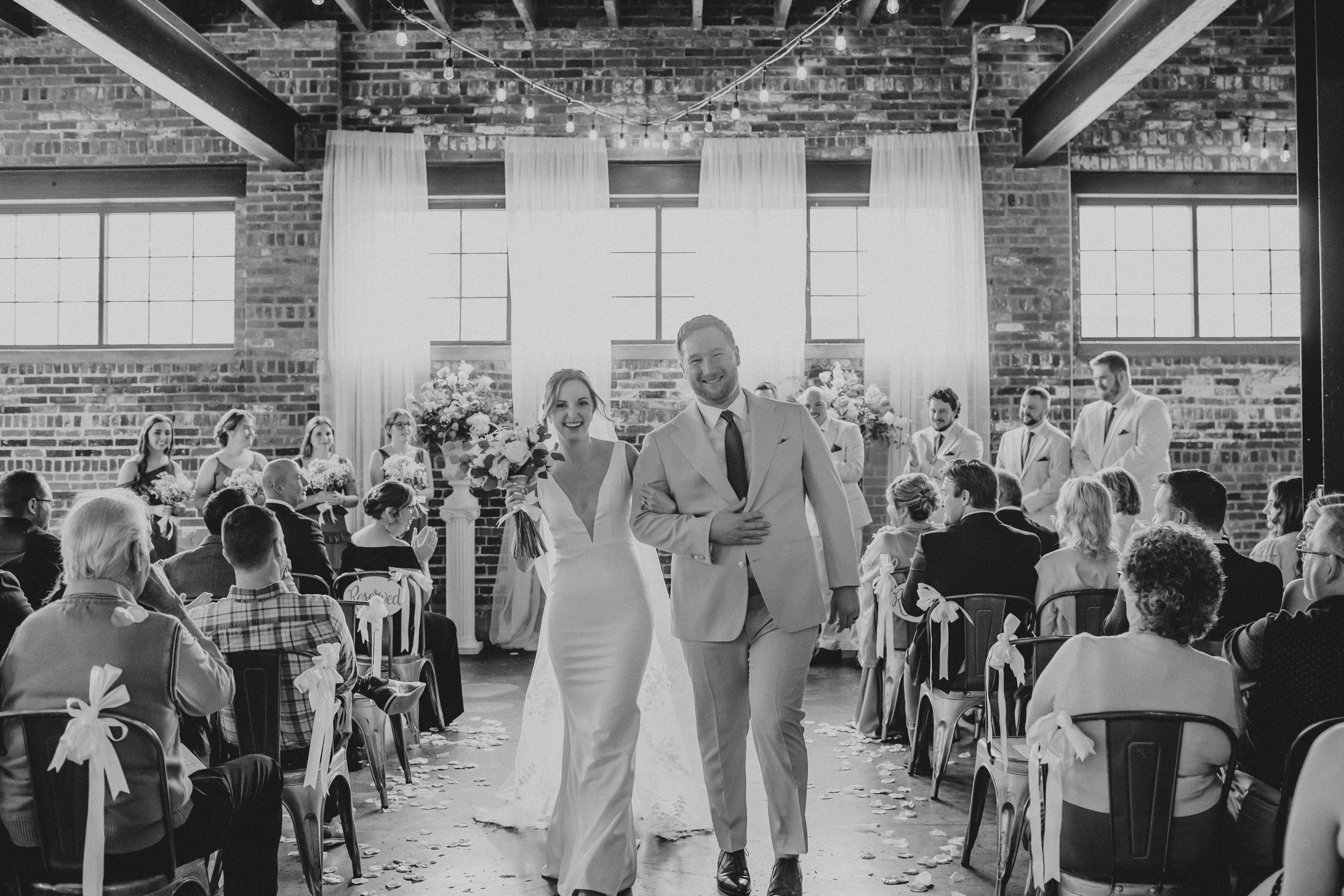 A black and white photo montage showing a wedding reception with guests dancing and celebrating in an industrial venue.