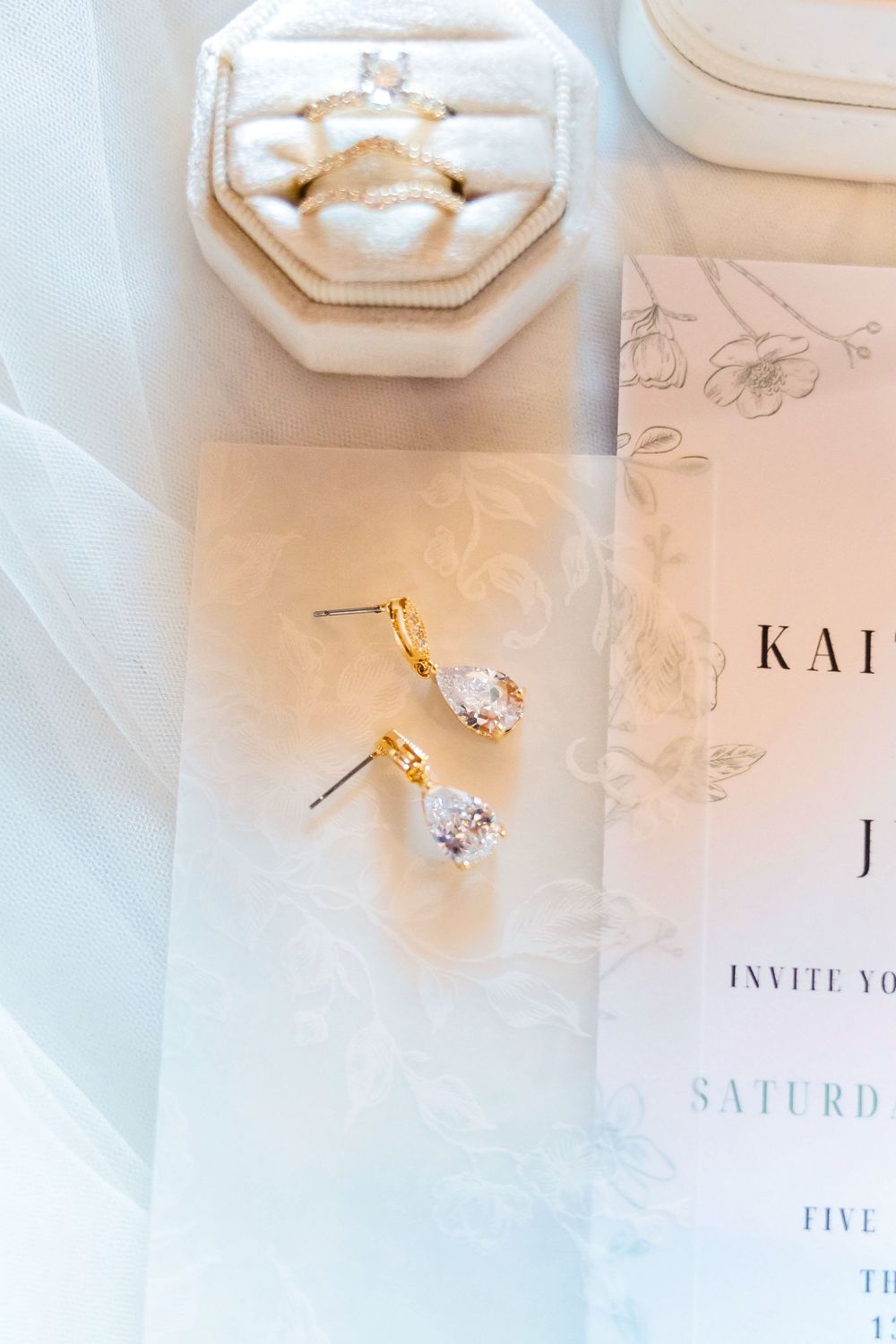 Wedding rings and earrings on invitation at The Venue On Lake Grant In Mt Orab Ohio: Cincinnati wedding photographer