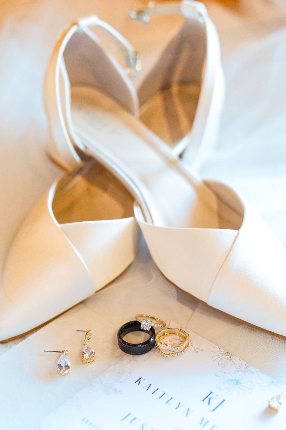 Wedding rings and earrings on invitation at The Venue On Lake Grant in Mt. Orab Ohio with wedding heels: Cincinnati wedding photographer