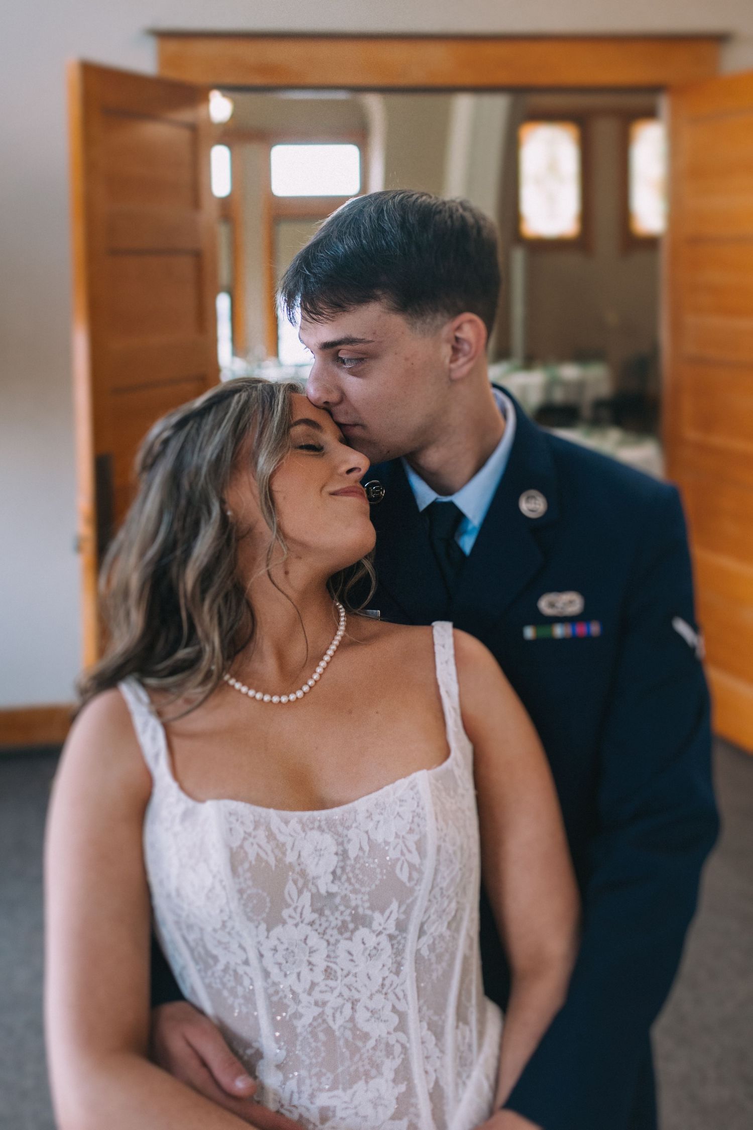 Intimate wedding portraits showing tender moments between newlyweds against wooden walls.