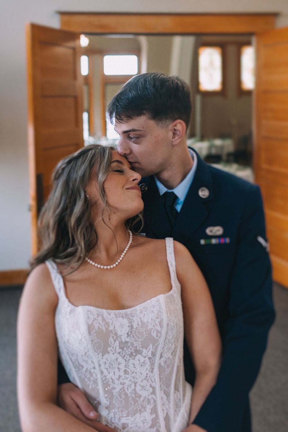Intimate wedding portraits showing tender moments between newlyweds against wooden walls.
