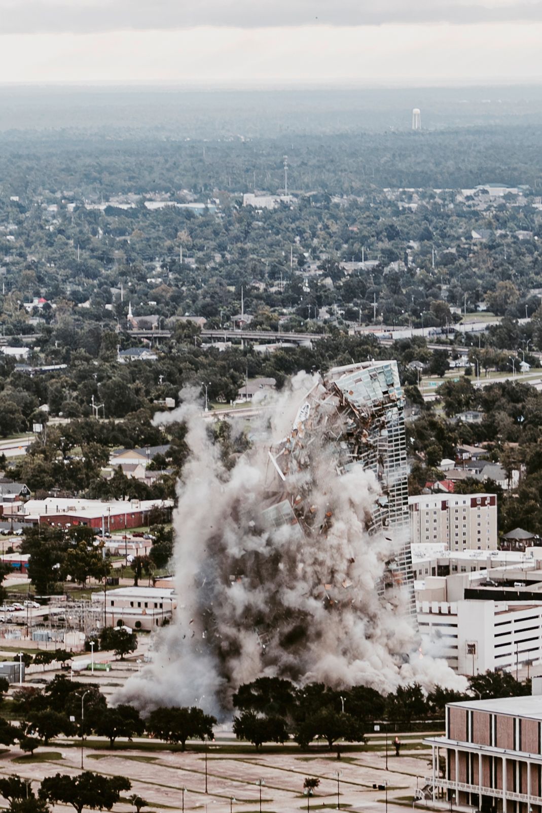 Building demolition creating massive dust cloud in an urban setting.