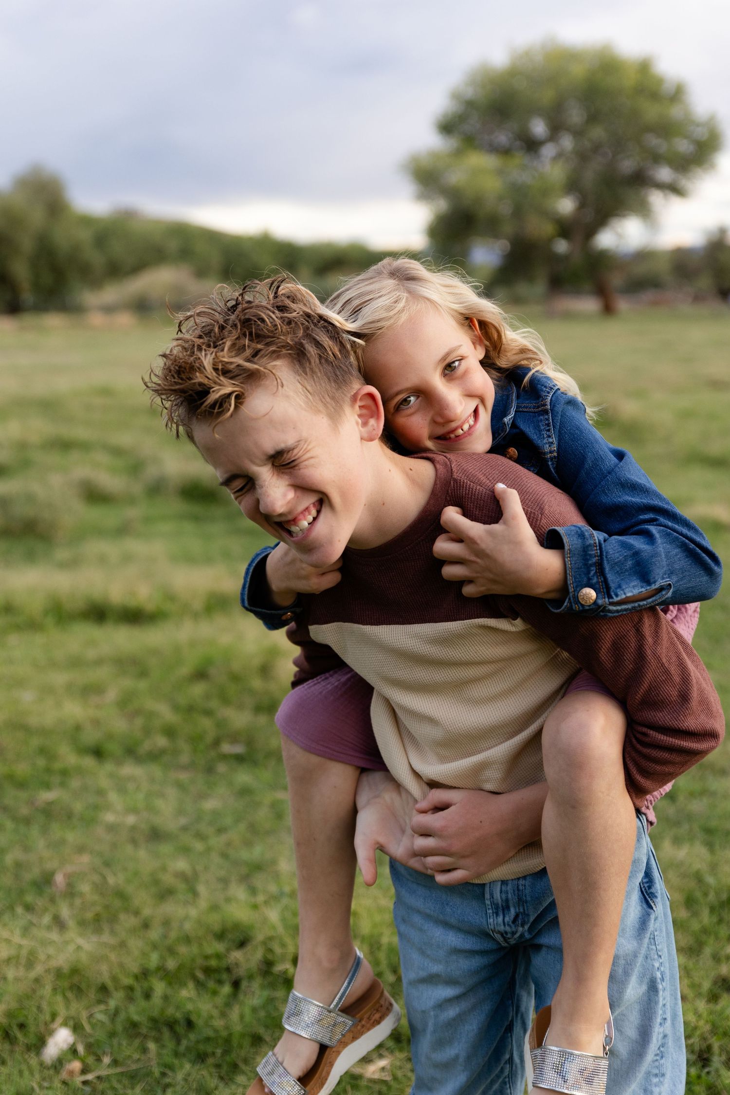 13 year old brother giving 10 year old a piggy back laughing