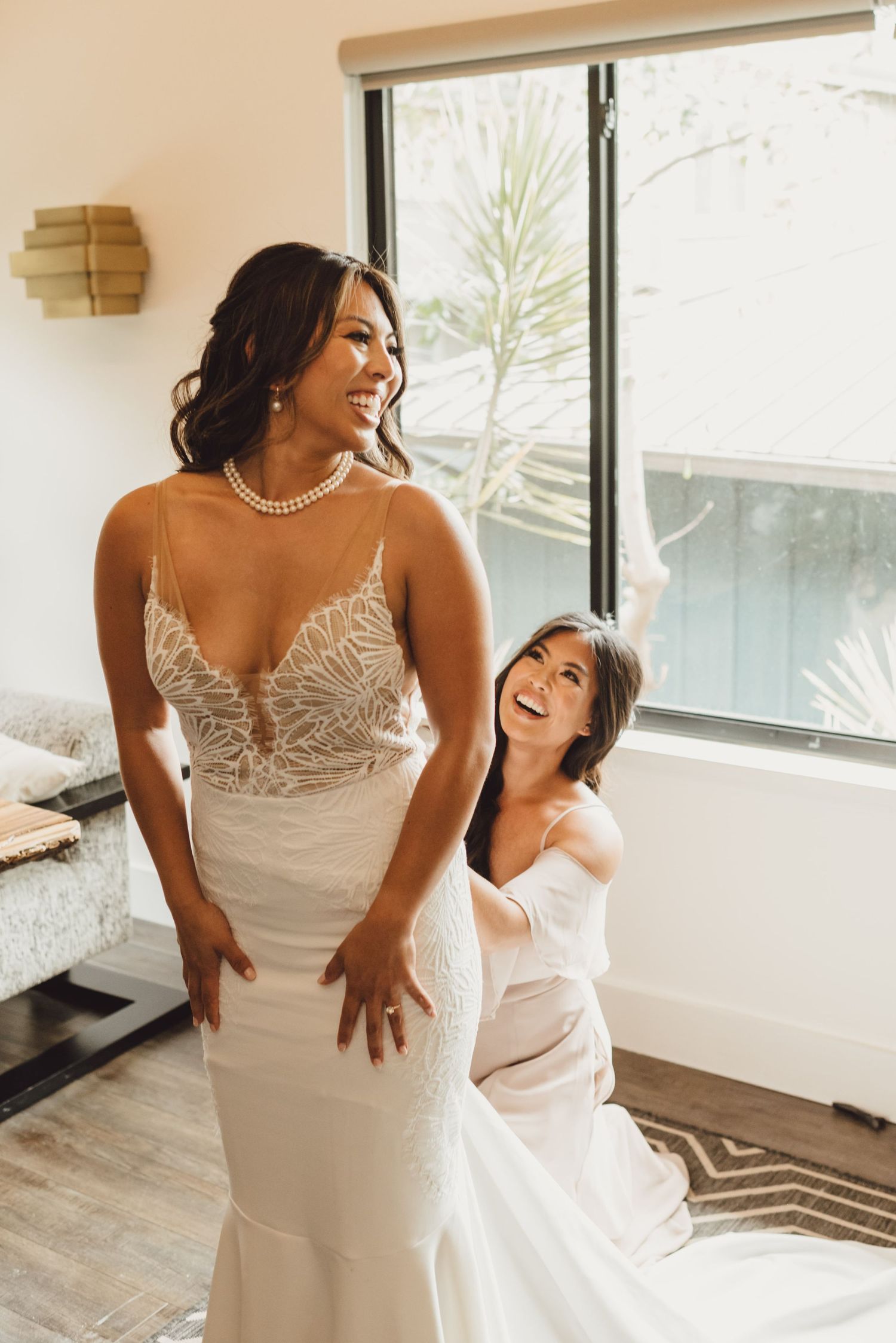 Two people share joyful moments while getting ready in a bright, modern room.
