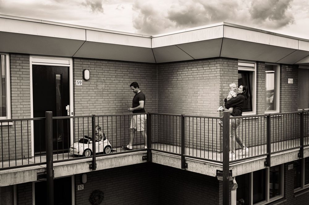 Panoramic view of a modern apartment building exterior with brick walls and balconies.