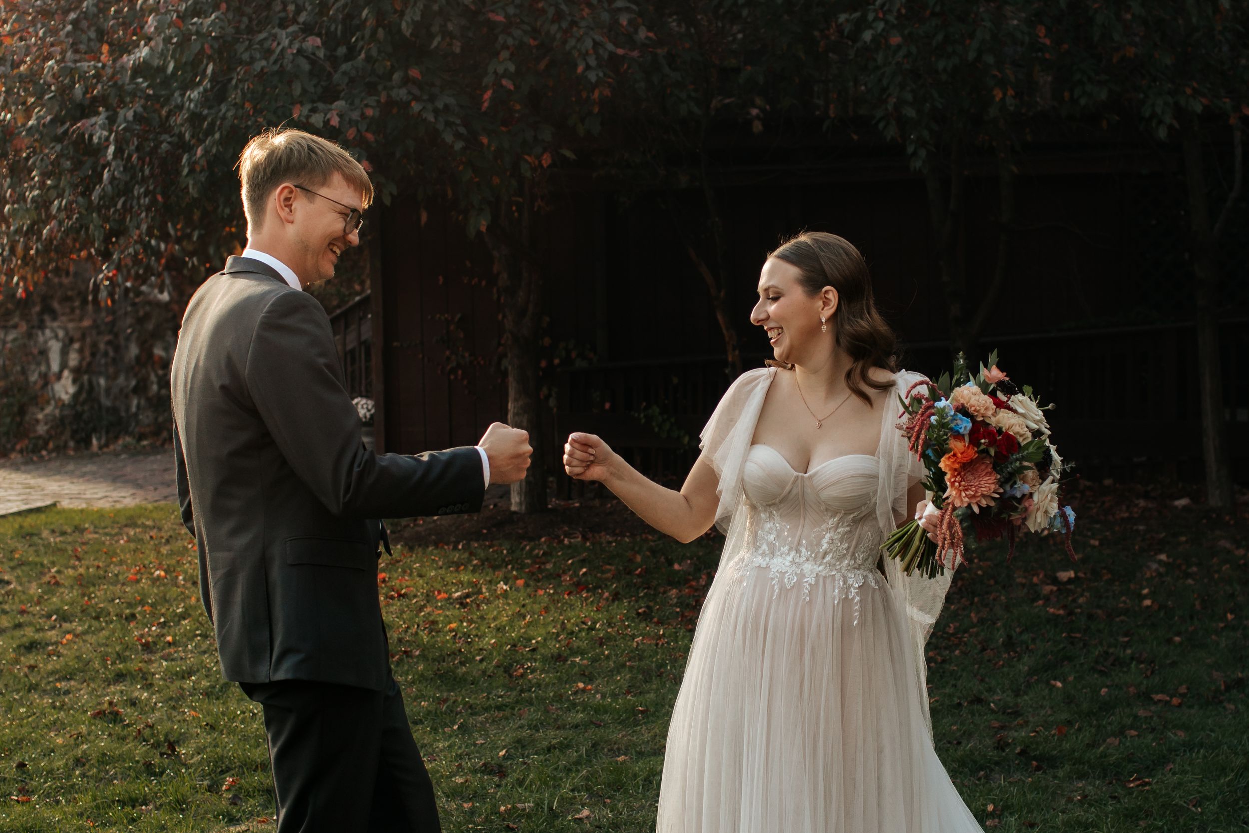 Couple sharing intimate moment during sunset wedding ceremony outdoors.