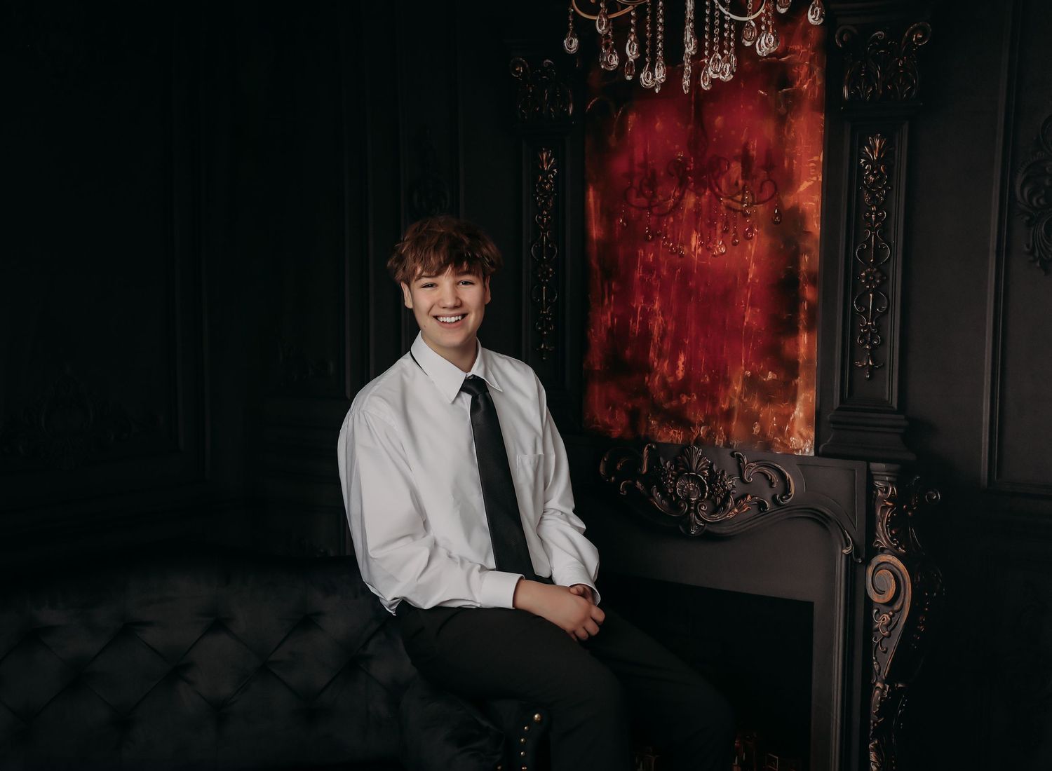 Wedding party poses together in dark moody venue with red lighting and elegant decor.