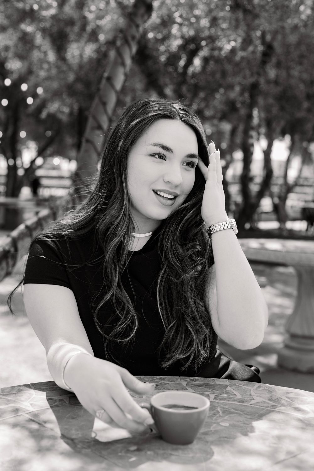 Black and white photos capture someone sipping coffee at a marble table in a garden setting.