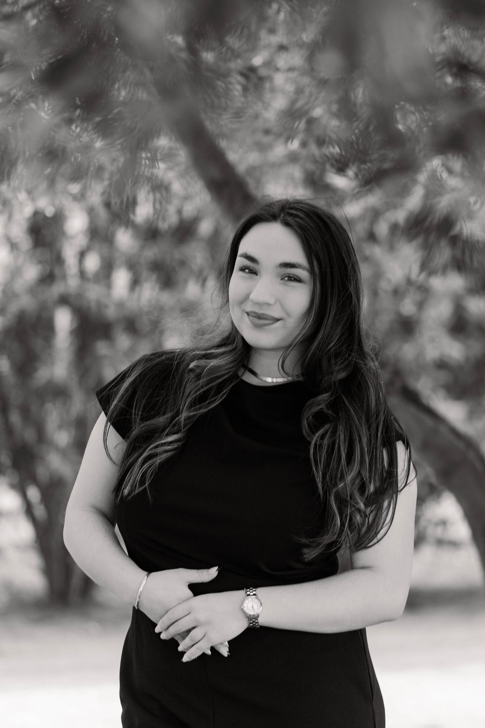 Black and white portrait series showing casual poses in a park setting.