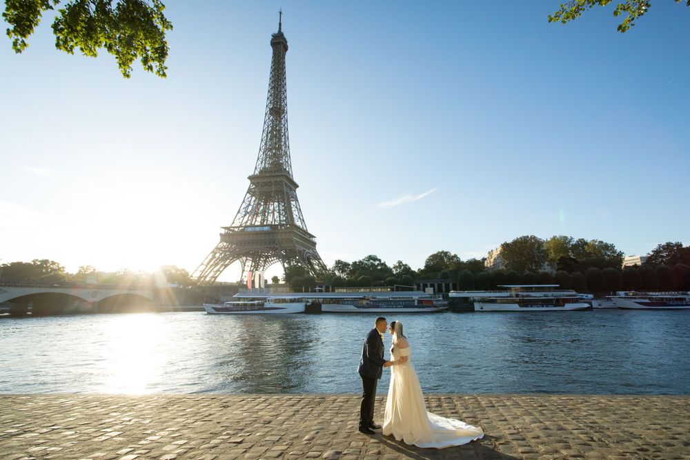 Panoramic sequence of the Eiffel Tower in Paris at sunset with bride and groom silhouettes against a bright blue sky. Elopement and emotions
