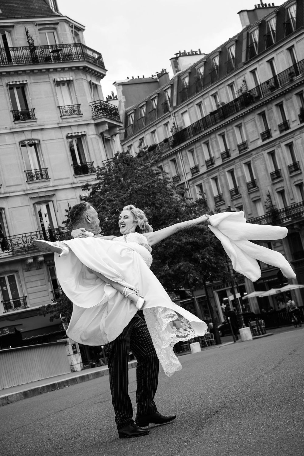 A romantic black and white dance scene in Paris with elegant architecture and classic buildings in the background.