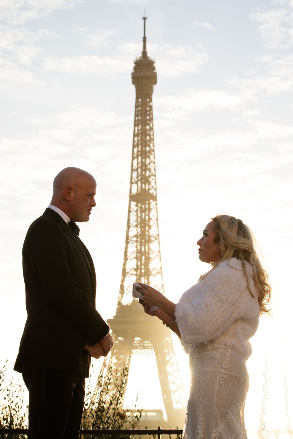 Silhouettes of couples eloping in paris, stand against a sunset backdrop with the iconic Eiffel Tower in Paris, France.