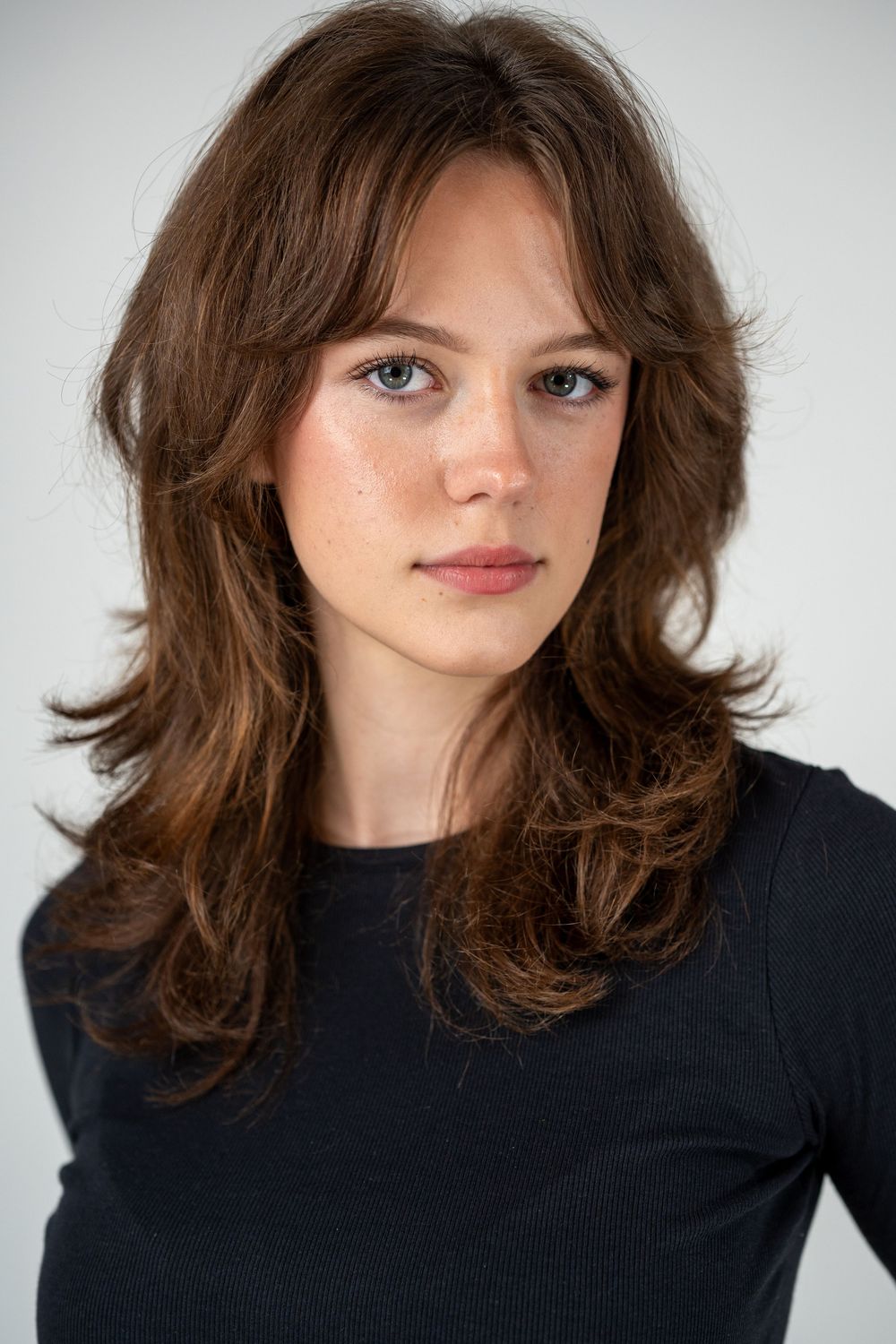 Portrait series showing a person with tousled brown hair wearing a black sweater against a light background.