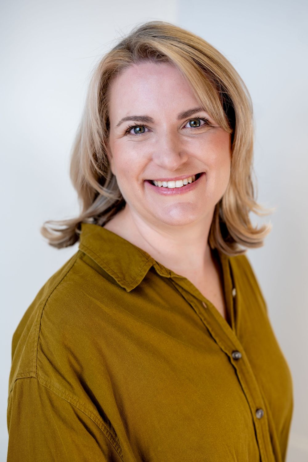 Professional headshots of someone in a brown collared shirt shown in 4 different poses against white background.