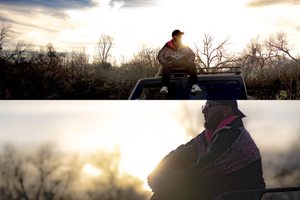 Silhouette of someone sitting on a car roof against a dramatic sunset with bare trees in the background.