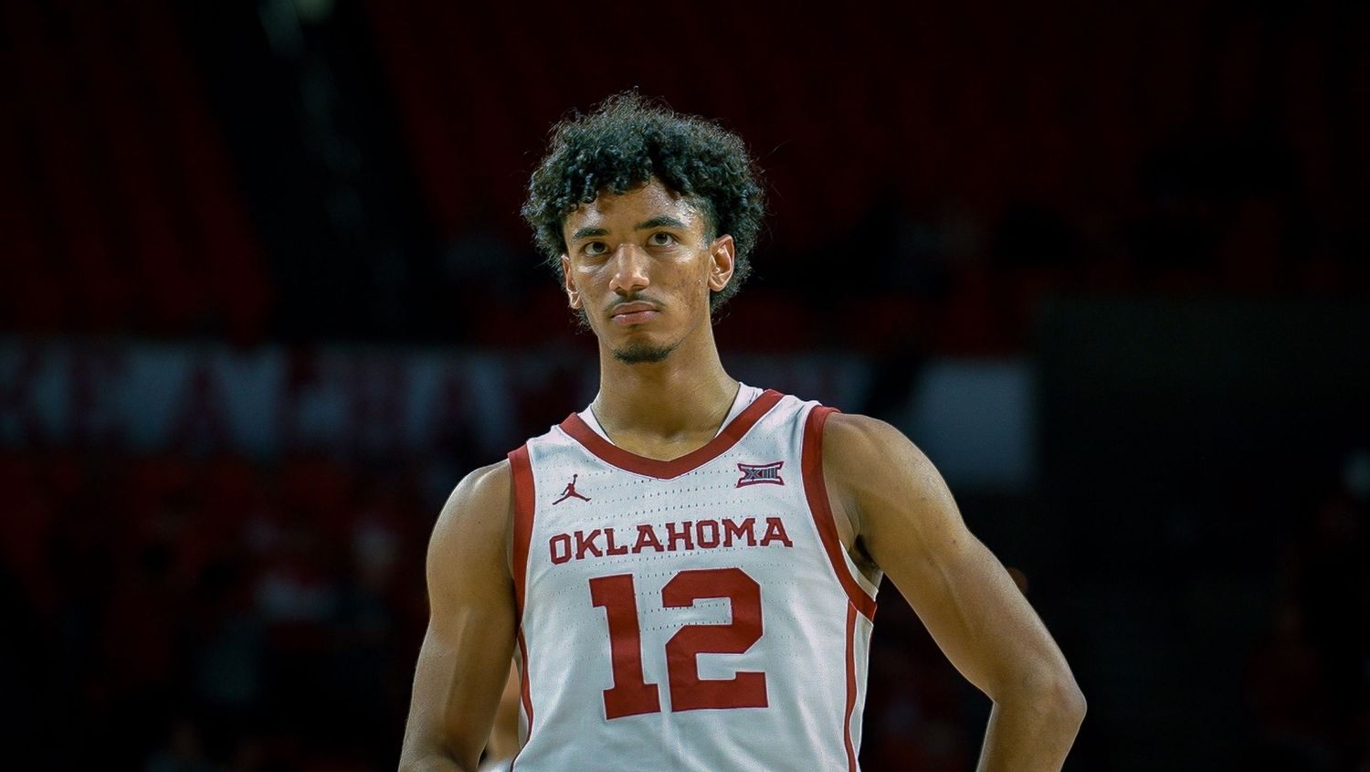 Oklahoma basketball player in white jersey number 12 stands focused during game.