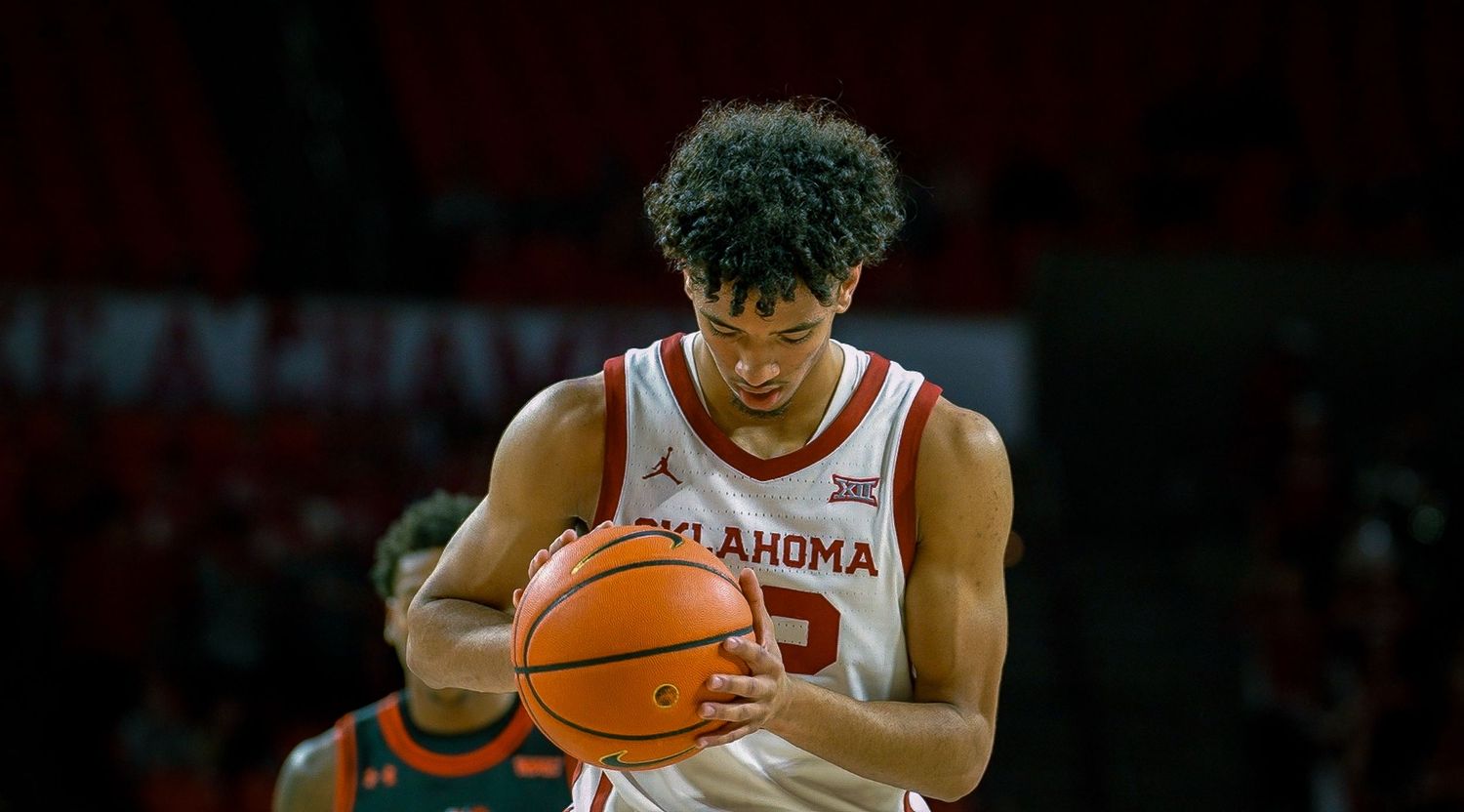 College basketball player shooting the ball during an Arkansas Razorbacks game at Bud Walton Arena.