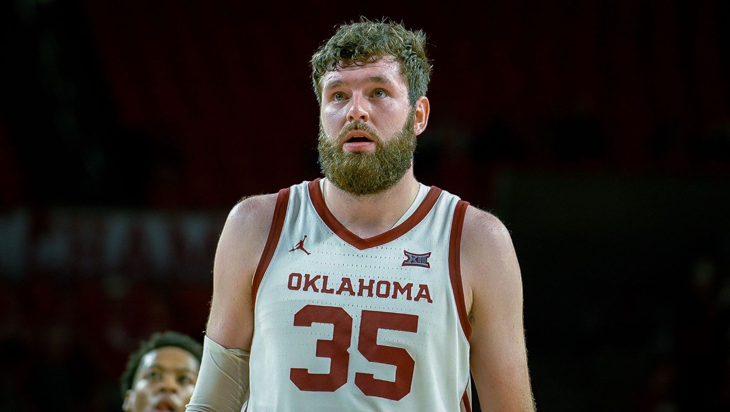 Bearded basketball player in Oklahoma jersey number 35 stands on basketball court during game.