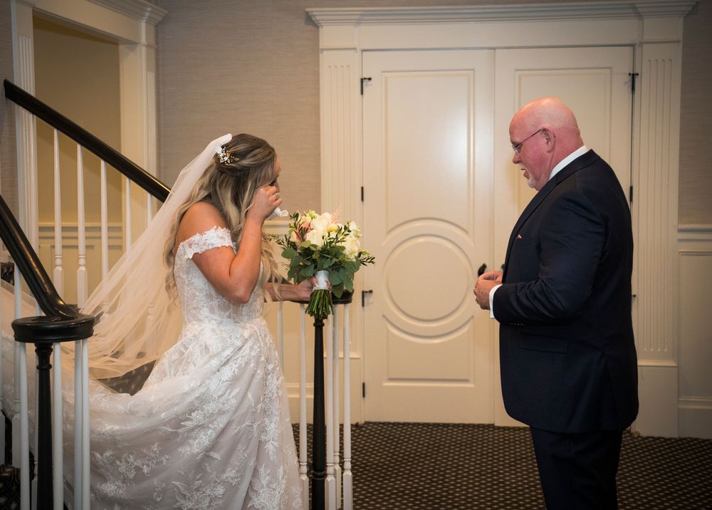 Wedding couple walking through elegant indoor hallway in formal attire.