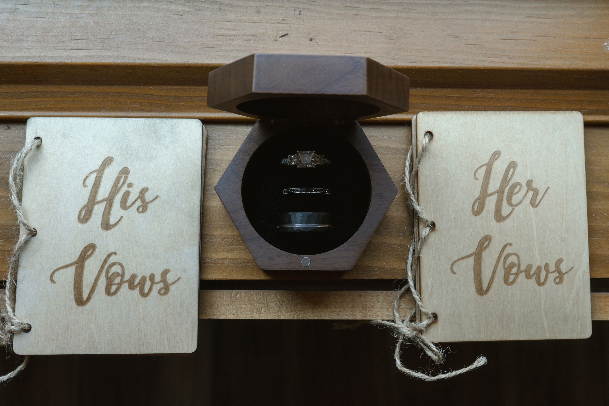 His and Her vows books displayed with wooden box for wedding ceremony.