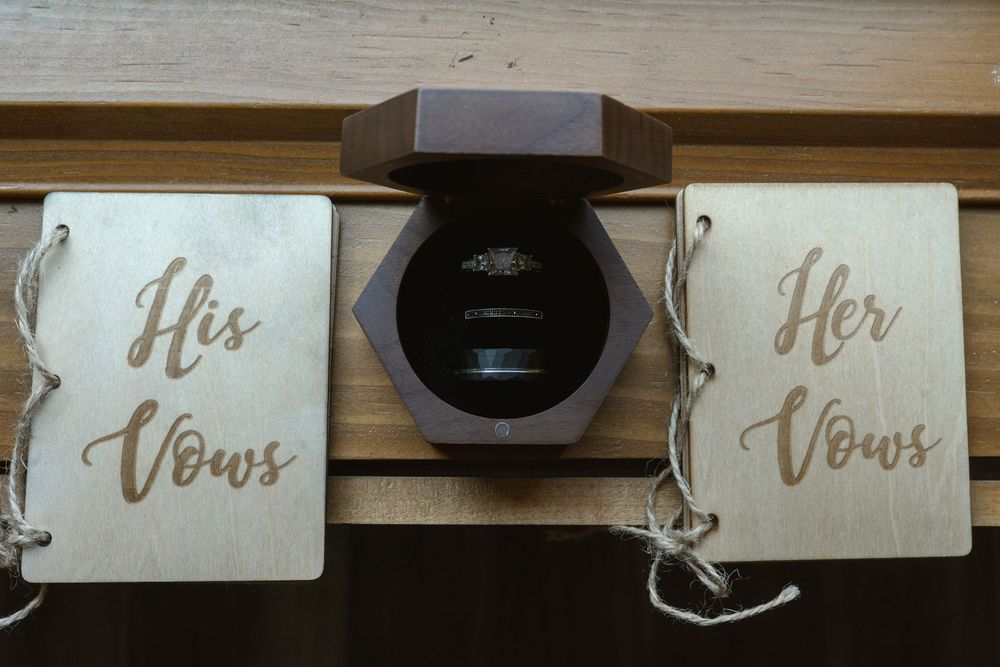 His and Her vows books displayed with wooden box for wedding ceremony.