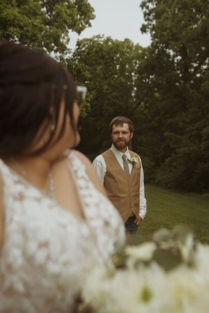 Candid wedding portrait capturing moment between couple in outdoor garden setting.