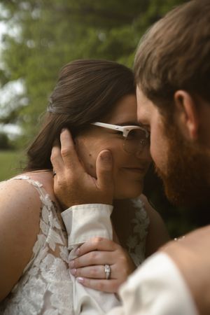 Intimate wedding moment captured in soft natural lighting outdoors.