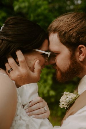 Close-up wedding photograph showing delicate details of a romantic moment outdoors.