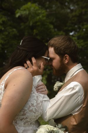 Tender wedding scene with white lace dress details in an outdoor garden setting.