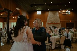An intimate dance moment during a wedding reception in a rustic wooden venue.