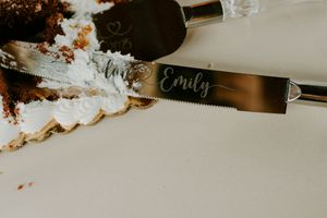 Elegant table settings with gold utensils and name cards at a wedding reception.
