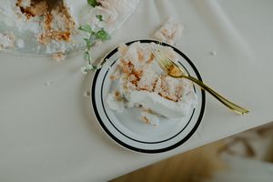 Wedding reception table settings with elegant white plates and leftover cake crumbs.