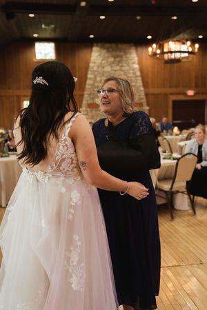 Wedding celebration in a rustic venue with wooden floors and stone walls.