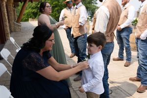 Wedding preparation moment showing final adjustments being made outdoors.