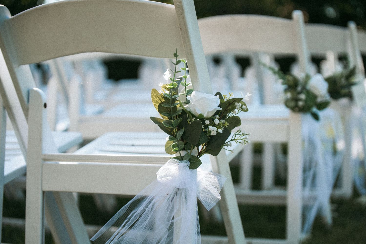 Close-up of bride's hands holding fresh green stem wedding bouquet.