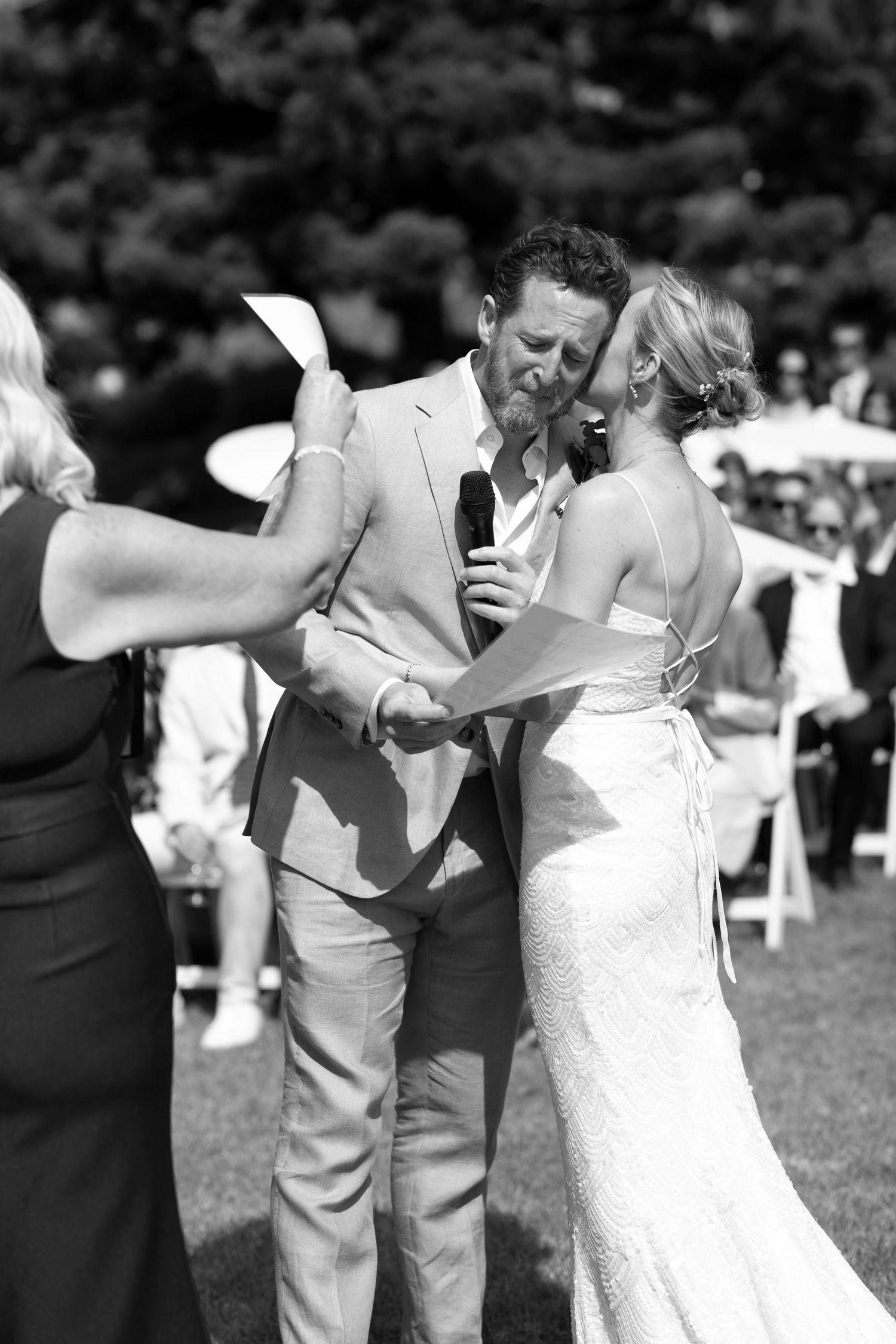 A couple shares an intimate dance moment at an outdoor wedding reception in black and white photography.