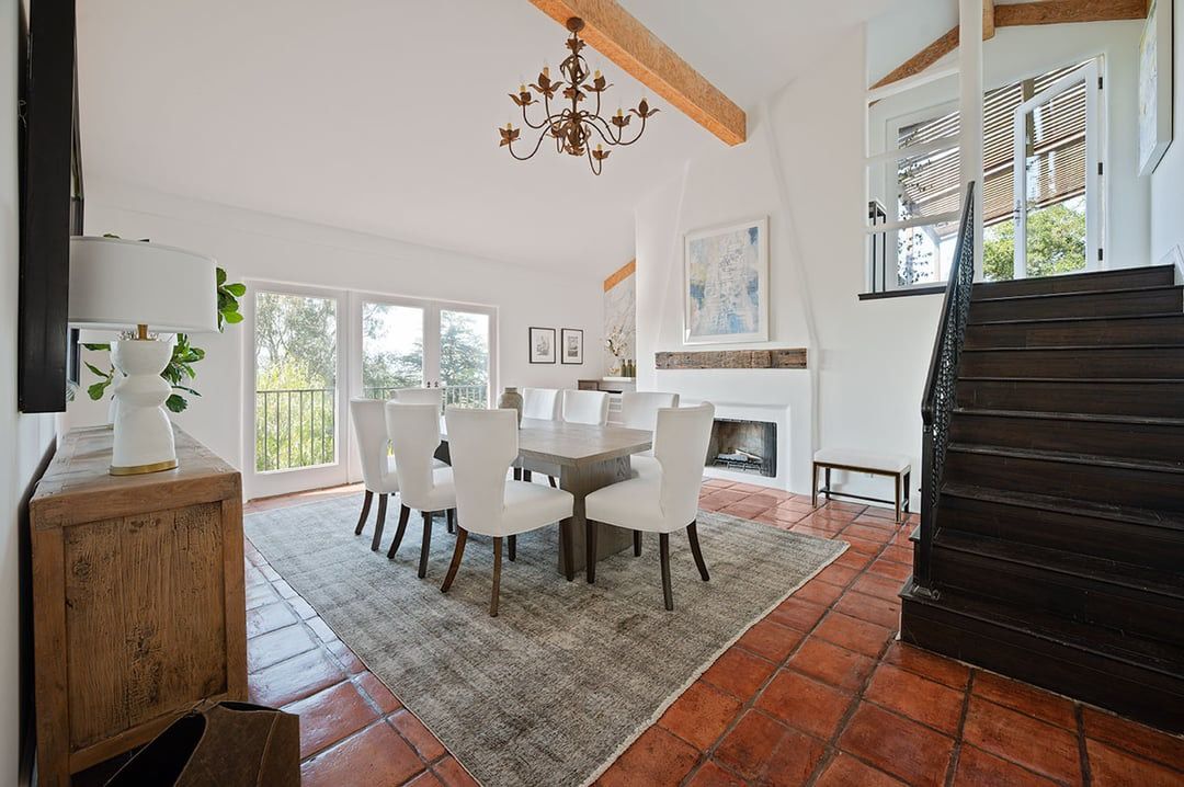 Modern white living spaces with vaulted ceilings and hardwood floors connect in an open concept layout.