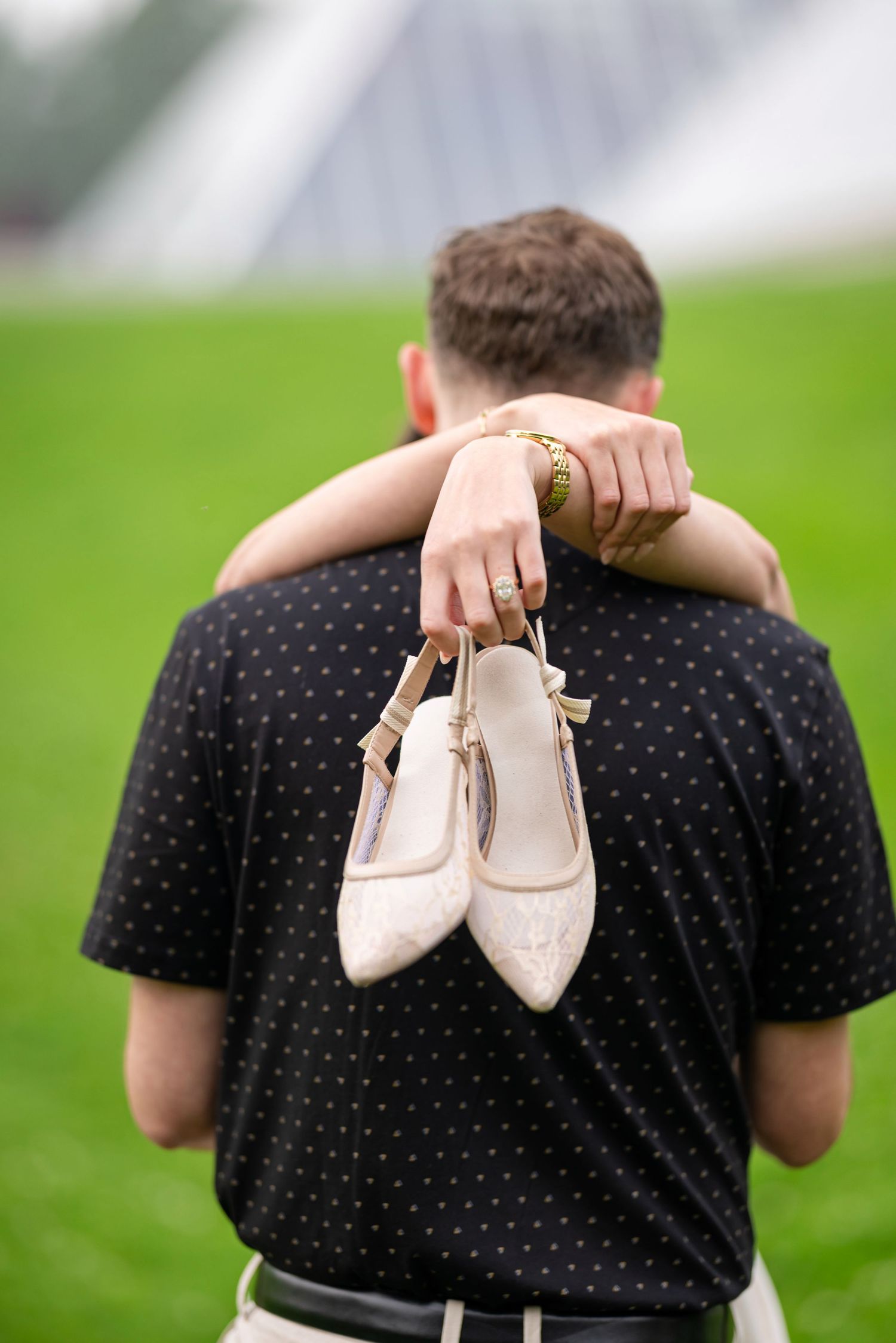 Romantic couple sharing a playful moment on a park bench surrounded by lush greenery.