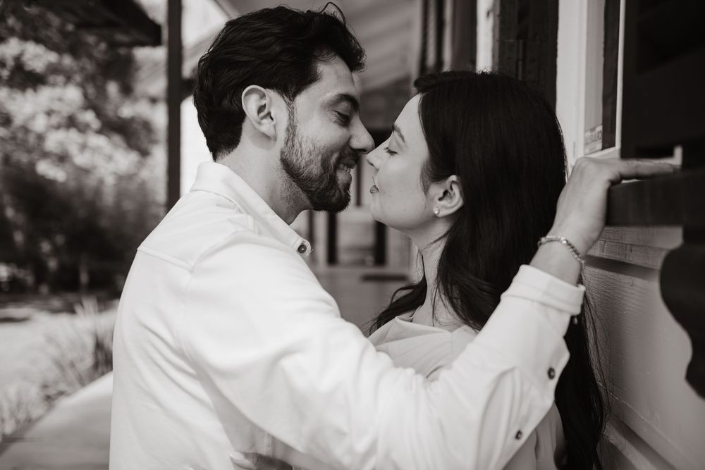 A romantic collage of five intimate black and white moments showing tender embraces and kisses.