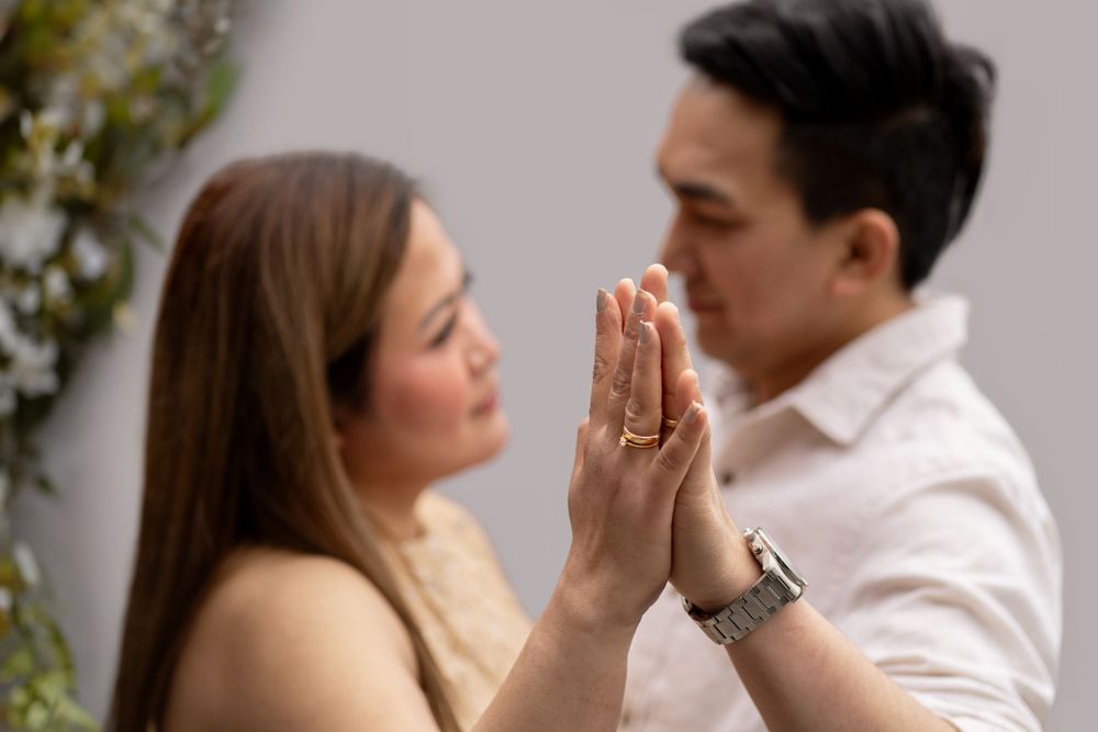 Romantic moment captured showing hands pressed together highlighting wedding rings.